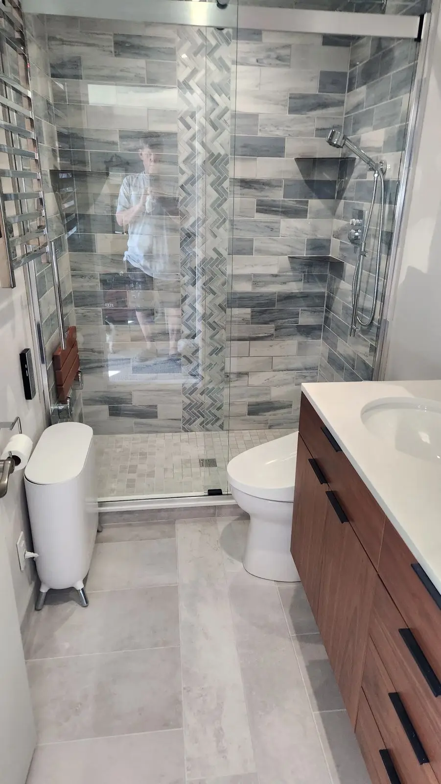 Bathroom with glass shower, gray tile and walnut vanity