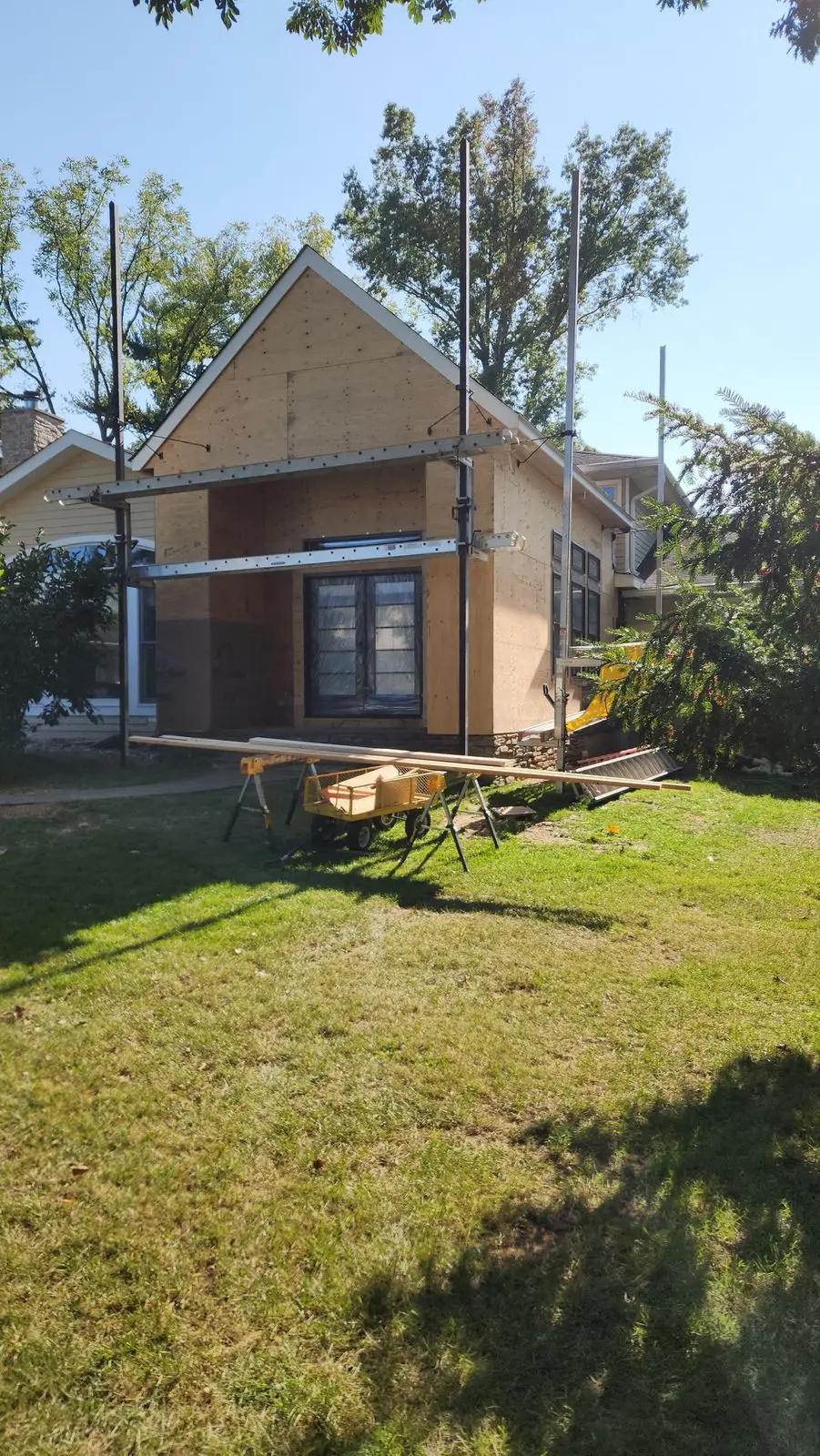 Gable addition under construction, sheathed and scaffolded