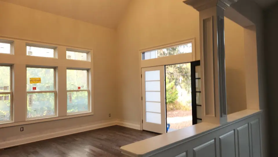 Vaulted room with transom windows and a glass door