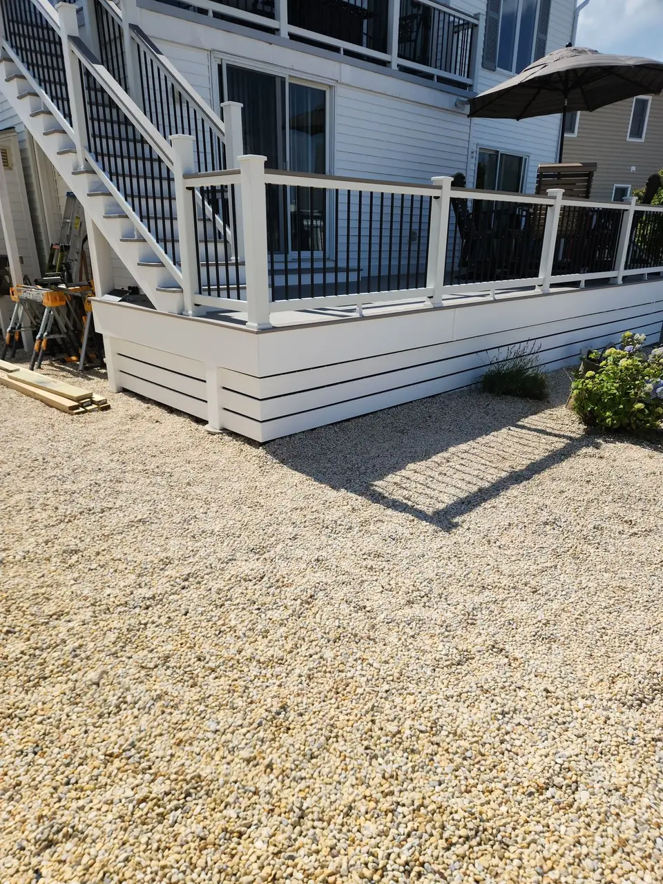 Raised deck with white railings, black balusters and stairs